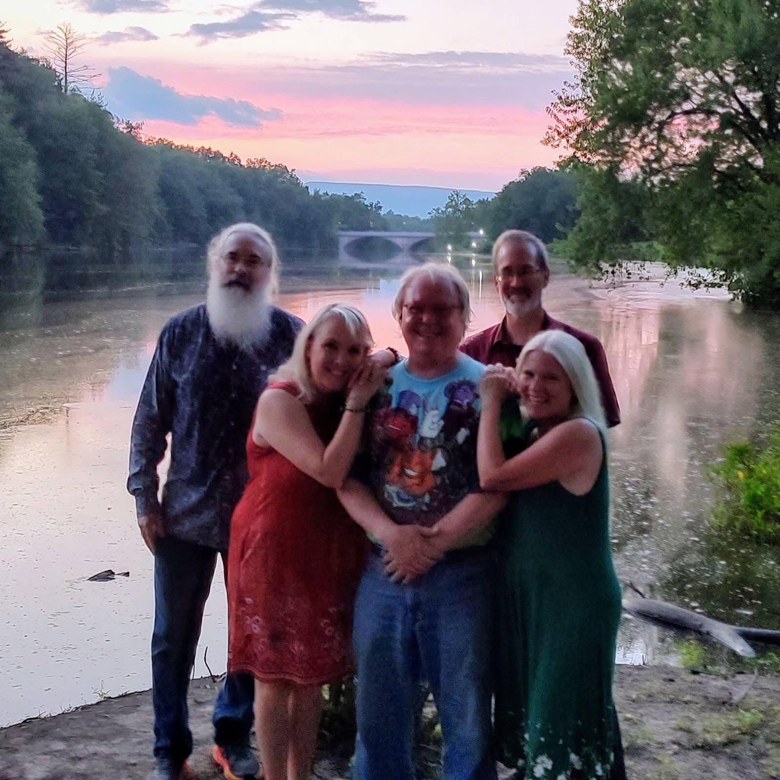 Oxford Station Band posing together at sunset by the river